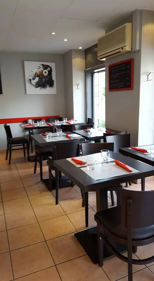 La salle du P'tit Café avec ses tables dressées et son ardoise